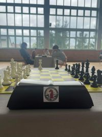 stanowisko do gry w szachy, w tle grający zawodnicy