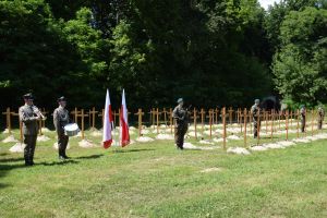 cmentarz, drewniane krzyże, żołnierze stojący przy grobach