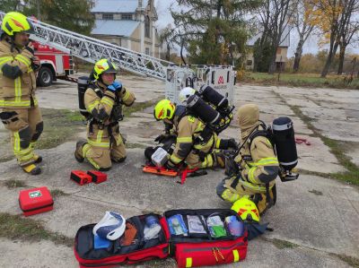 czterech strażaków w umundurowaniu przygotowujących się do...