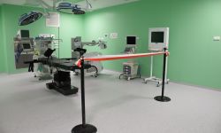 Sala operacyjna, stół operacyjny wraz z wyposażeniem, zielone ściany