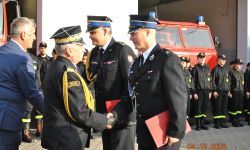 generał składa gratulacje dwóm strażakom