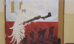 biało czerwony plakat, orzeł w locie trzyma w szponach karabin
