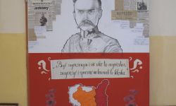 biało czerwony plakat, pośrodku postać Piłsudskiego, wycinki z gazet