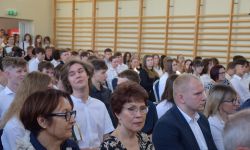uczniowie siedzący na sali gimnastycznej
