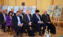 goście siedzący na krzesełkach, w tle obrazy na sztalugach