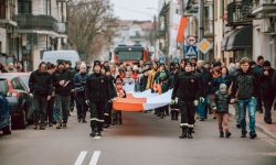 pochód ulicami miasta z flagą Polski