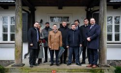 pamiątkowe zdjęcie na tle wiejskiej chaty