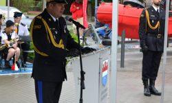 komendant główny przy mównicy przemawia do zaproszonych gości i strażaków