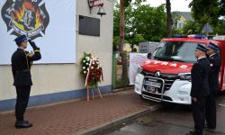 składanie kwiatów pod tablicą na terenie OSP NDM