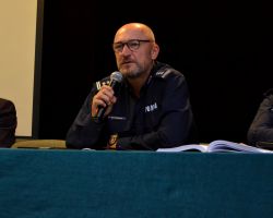 trzy osoby siedzą przy stole, od lewej wicestarosta nowodworski i dwóch policjantów