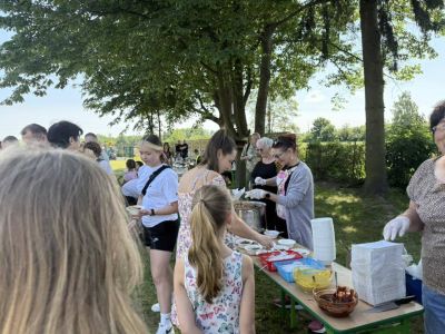 grupa ludzi częstująca się przygotowanym jedzeniem