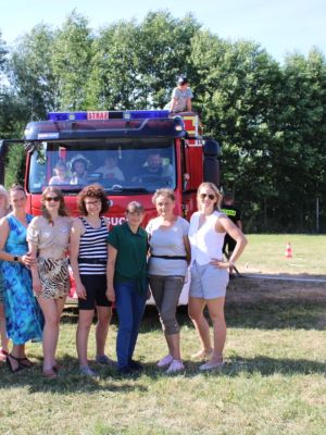 zdjęcie grupowe uczestników wydarzenia na tle wozu strażackiego