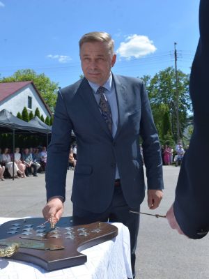 wicestarosta nowodworski Andrzej Pacocha przybija odznakę z fundatorami na pamiątce wręczenia sztandaru