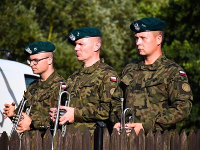 Przedstawiciele orkiestry wojskowej trzymają w dłoniach instrumenty