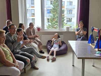podopieczni Środowiskowego Domu Samopomocy siedzą i oglądają występ pacynek