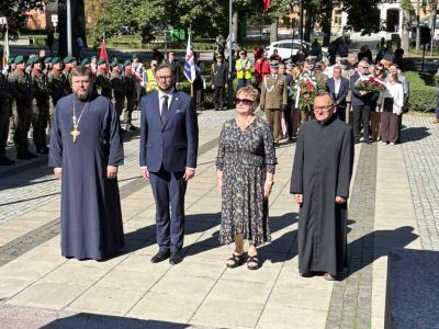 Delegacja UM i duchownych stoi