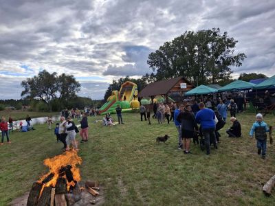 ognisko, w tle widok na dmuchaniec i uczestników wydarzenia
