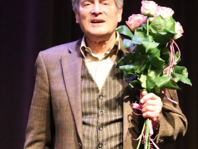 Pan Jerzy Zelnik trzyma bukiet róż