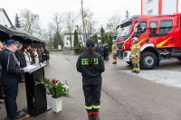 zdjęcie zza pleców strażaka, widok w tle na wóz