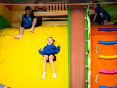 dzieci zjeżdżają z dmuchanej zjeżdżalni