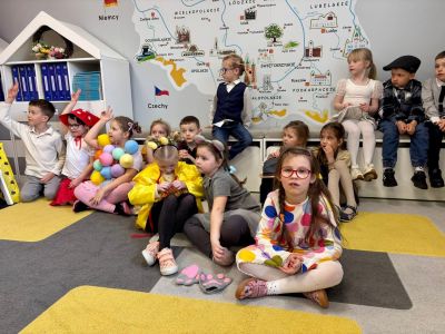 dzieci siedzą na dywanie