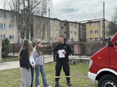 uczennice przed wozem strażackim wraz ze strażakiem