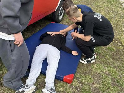 nauka pierwszej pomocy, uczeń leży na materacu