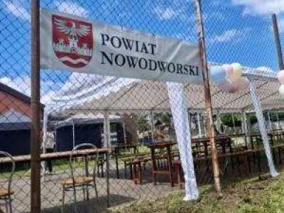 baner powiatu nowodworskiego wiszący na ogrodzeniu